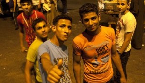 Young men pose for a photograph at Tahrir Square after the end of voting in the presidential election in Cairo